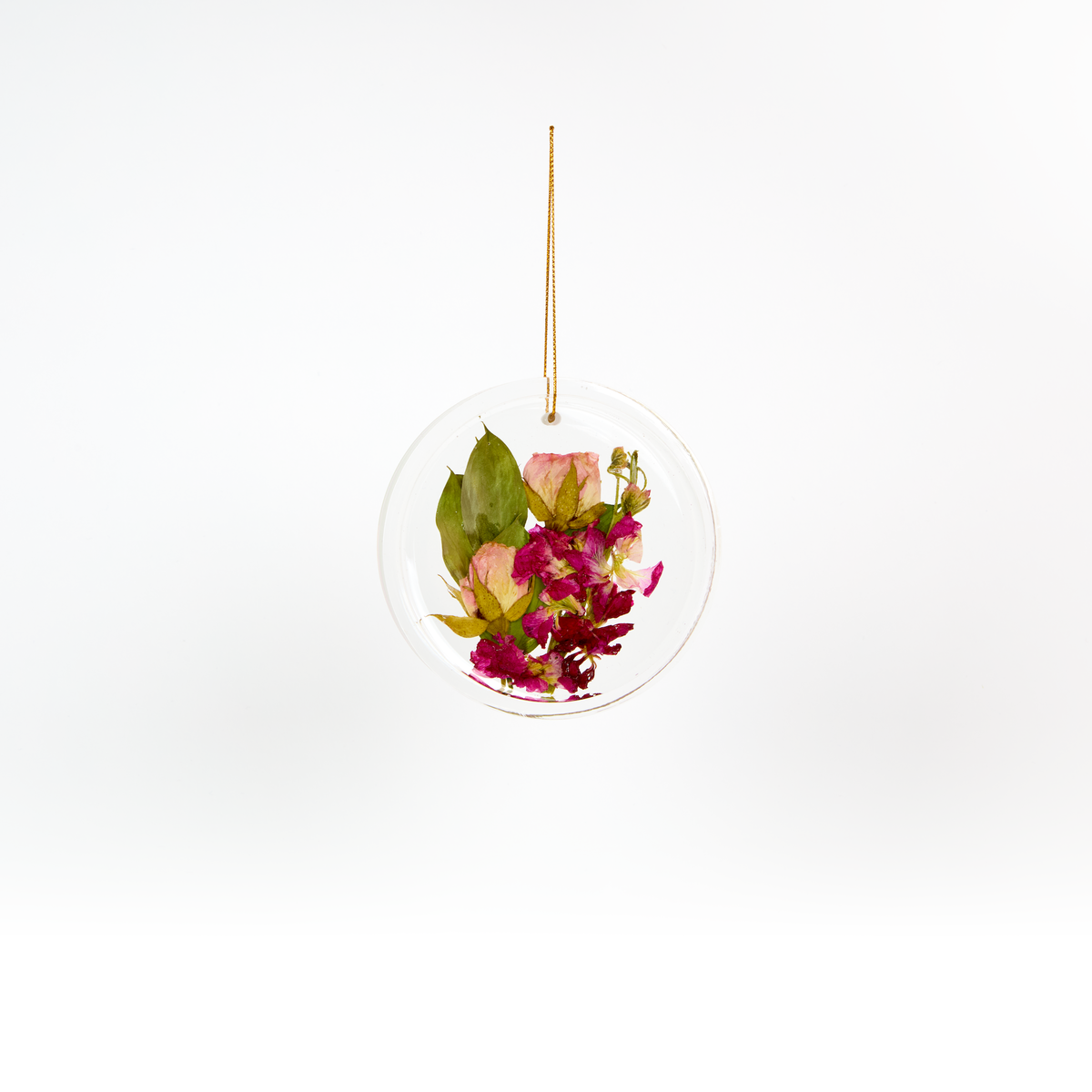 Pressed flower resin ornament in a circle shape to as a part of a wedding bouquet preservation order. 