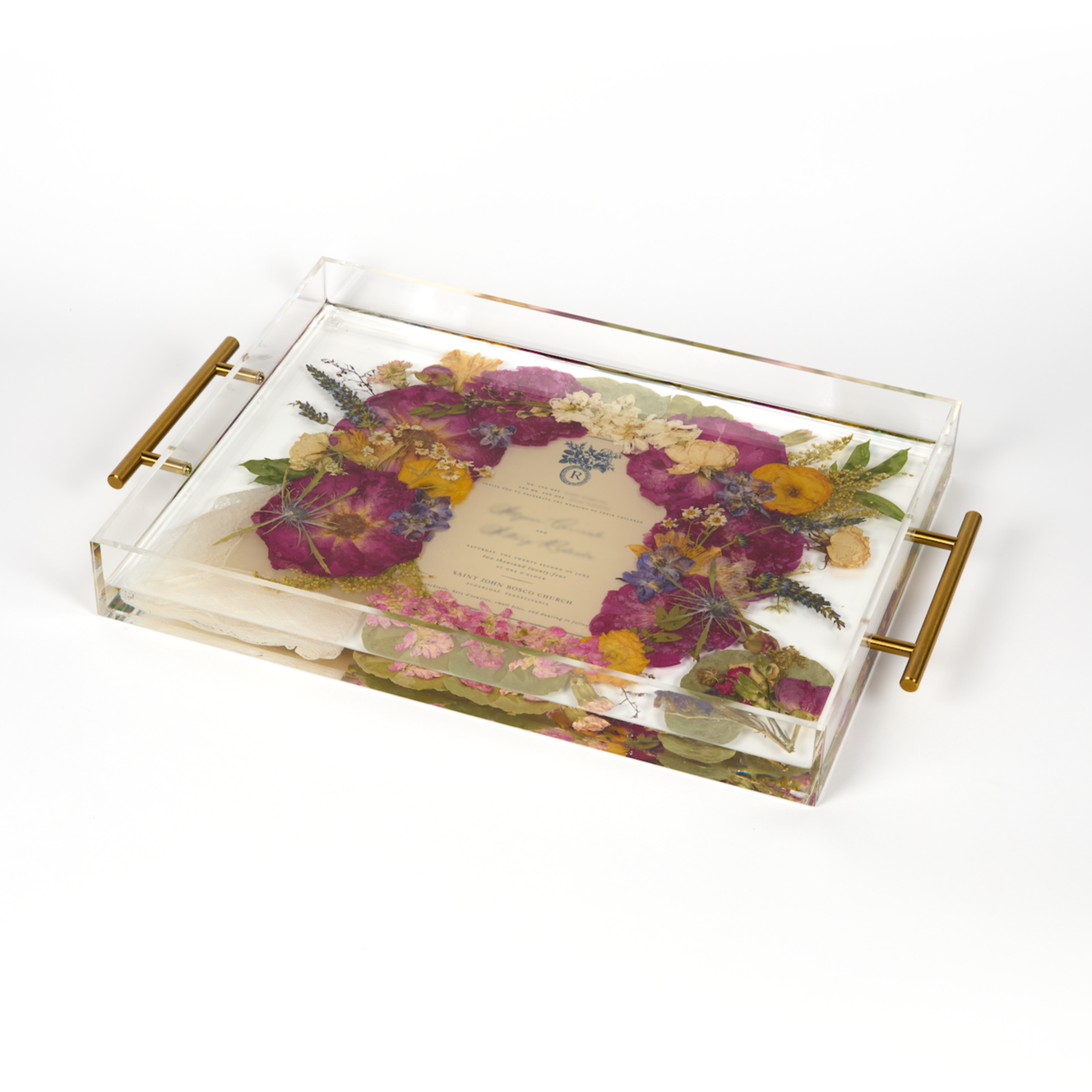 A pressed flower resin serving tray with vibrant colorful flowers and an invitation in the center. Wedding bouquet preservation as functional home decor. 