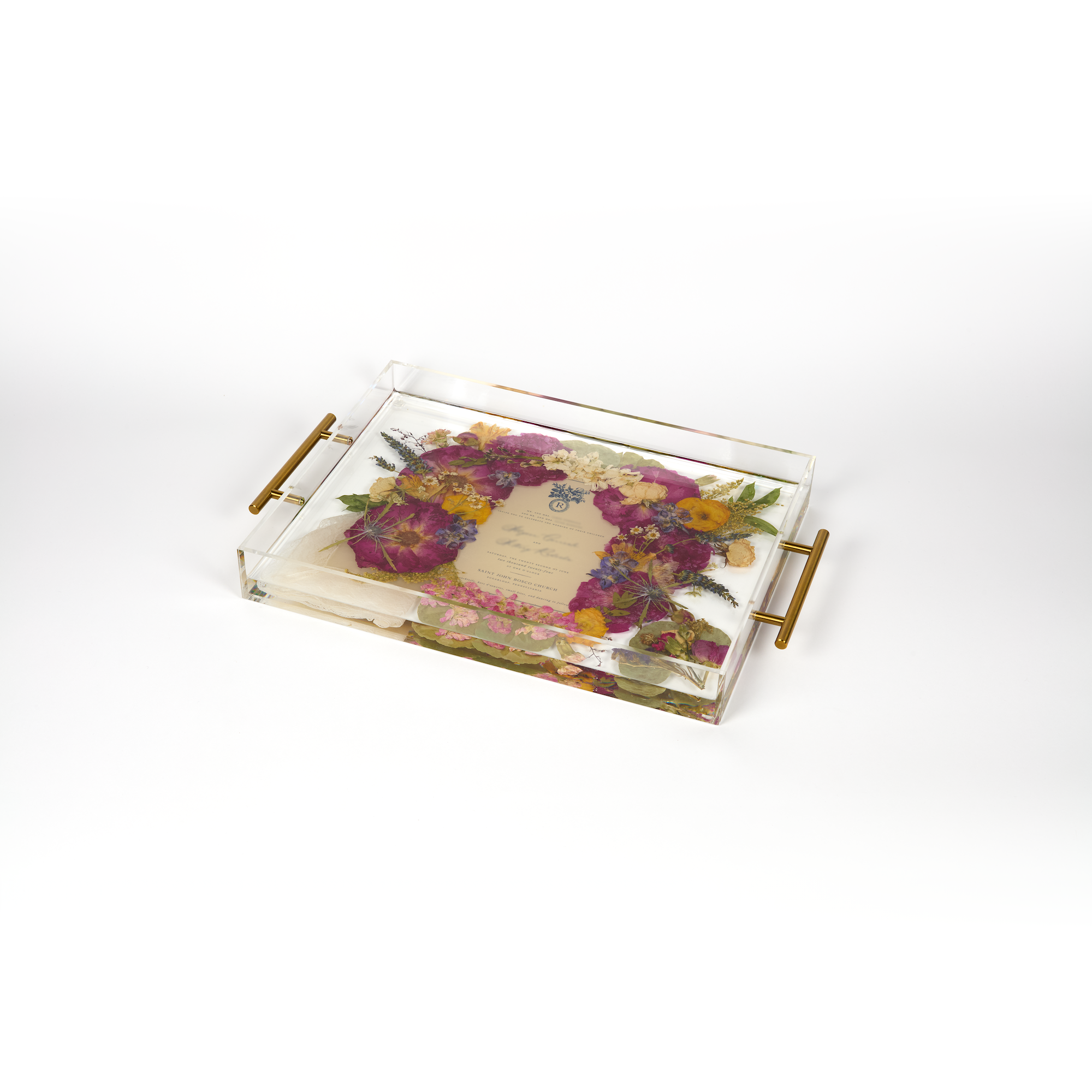 A pressed flower resin serving tray with vibrant colorful flowers and an invitation in the center. Wedding bouquet preservation as functional home decor. 