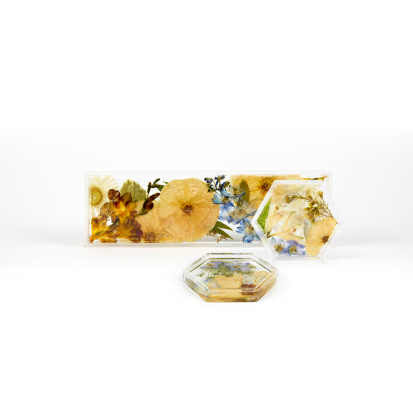 Pressed flower preservation of a wedding bouquet featuring blue, white, orange, and yellow toned preserved florals. A set of two floral resin ring dishes and a display tray. 