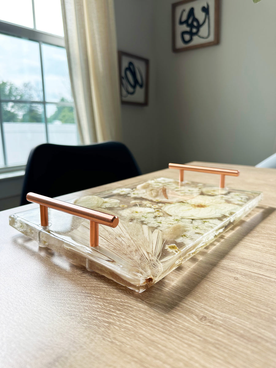 Rectangle resin serving tray with rose gold handles.