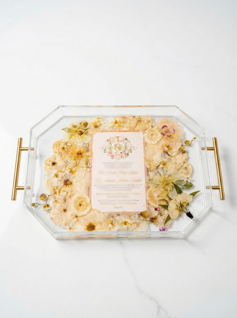 flowers pressed into a geometric serving tray with an invtiation and a boutonniere