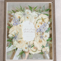 White, green, and blue florals pressed and preserved into a large wooden frame.