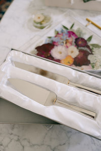 Gold ring handled wedding cake knife and server set from Element Marketplace, shown in gift box, next to resin serving tray