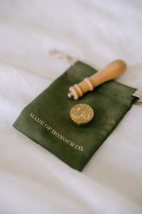 Brass wildflower wax seal stamp from Element Marketplace, shown separated on a cleaning cloth