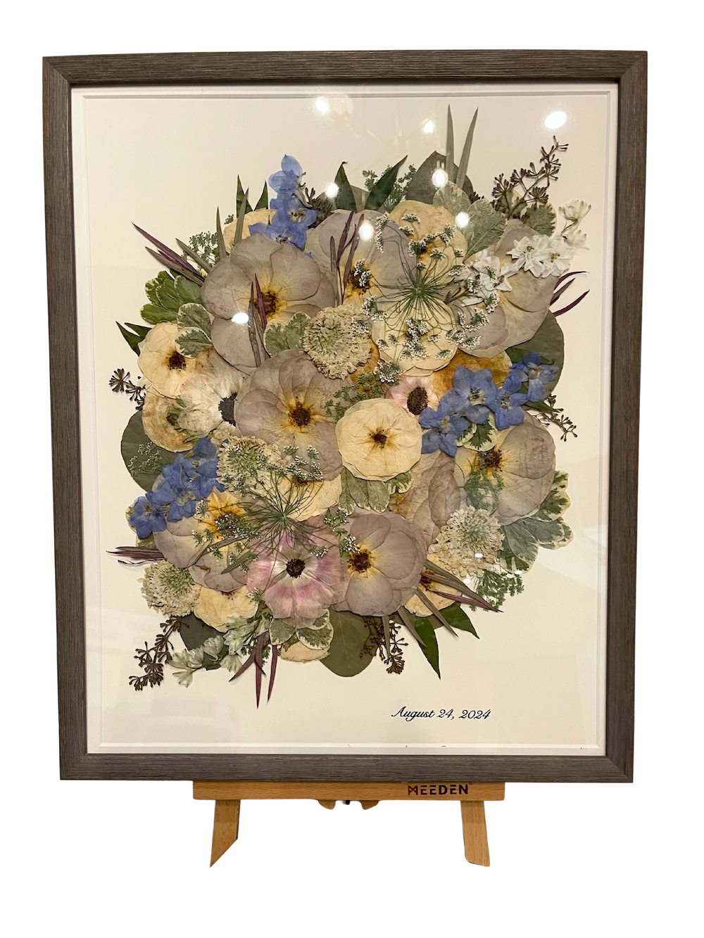 A preserved wedding bouquet in a barn wood frame with a wedding date in the bottom corner. 