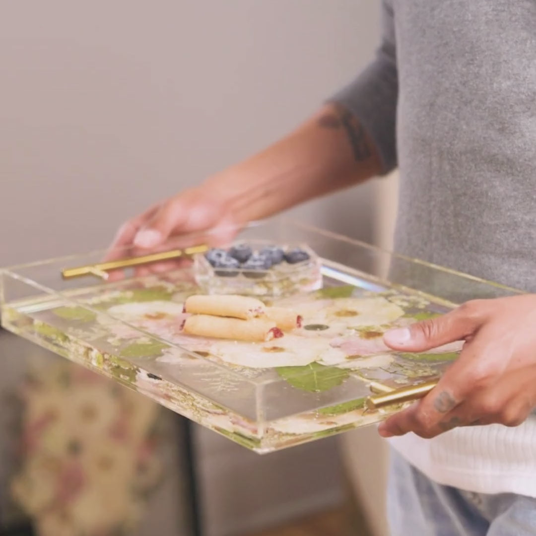 A man walks across the room holding his preserved wedding flower serving tray