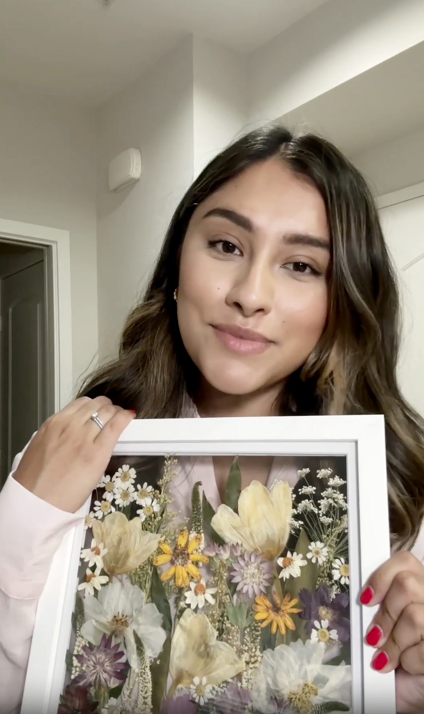 A woman explains her experience working with Element Design and shares some clips from her wedding day. She showcases her small bouquet preservation frame with dainty flowers pressed in field style. 