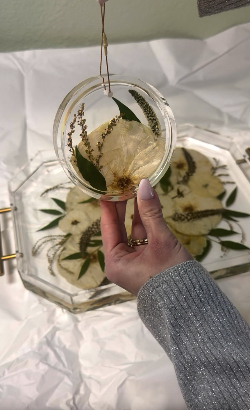 A woman records her Element Design experience with some video clips of her wedding day and the finished floral preservation products. The products include a serving tray, coasters, and an ornament from her white and green wedding bouquet. 