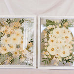 Two white wedding bouquets pressed in a 16x20" white wood frame