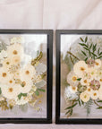 Two black wood frames with pressed wedding bouquets inside