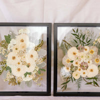 Two black wood frames with pressed wedding bouquets inside