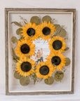 Barn wood frame with pressed sunflowers in burst style design with invitation